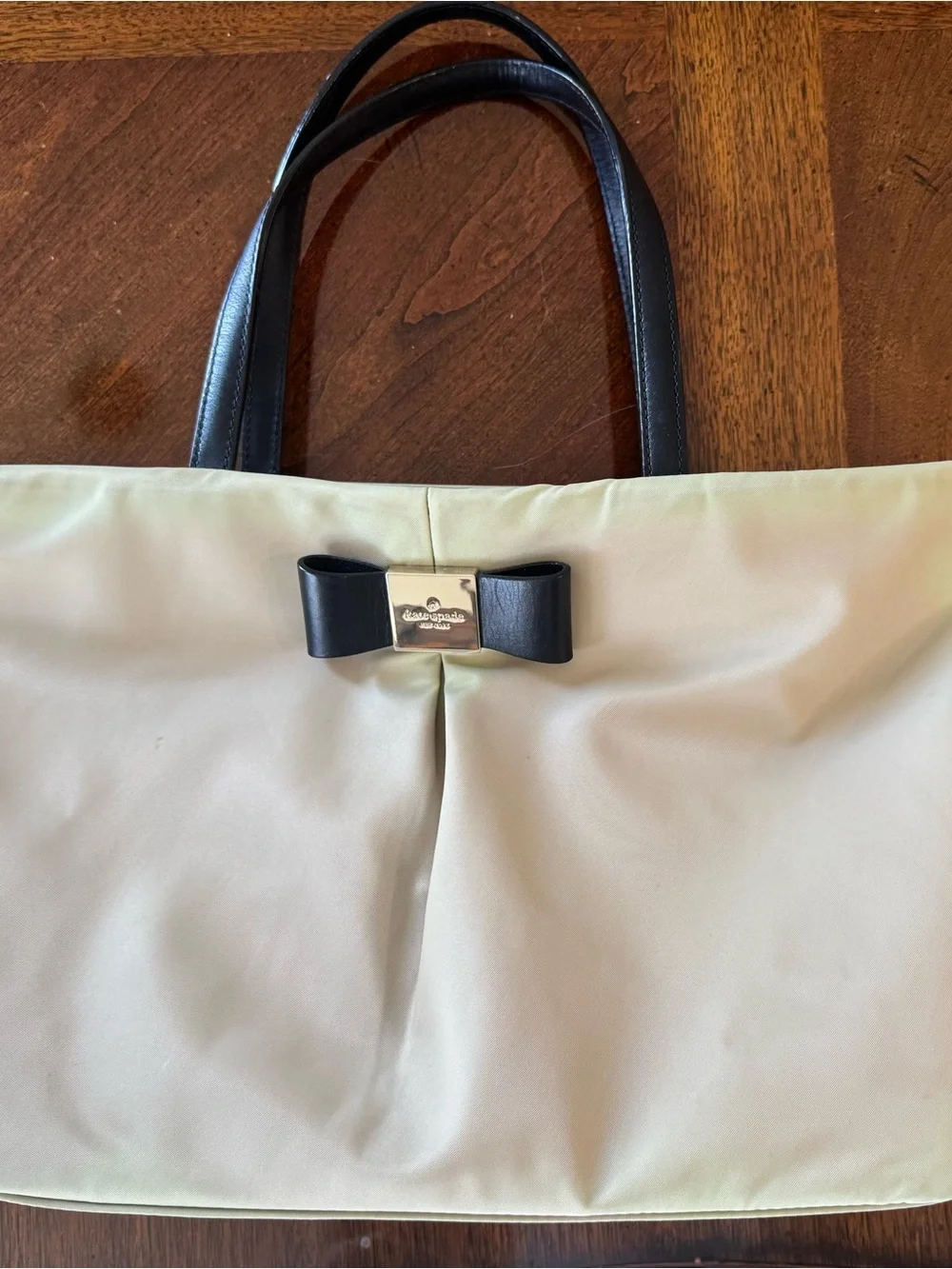 kate spade beige tote with black bow and straps